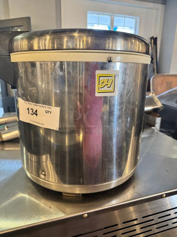 Stainless steel rice warmer for 50 cups, used condition, with brand logo and auction sticker showing "134 QTY".