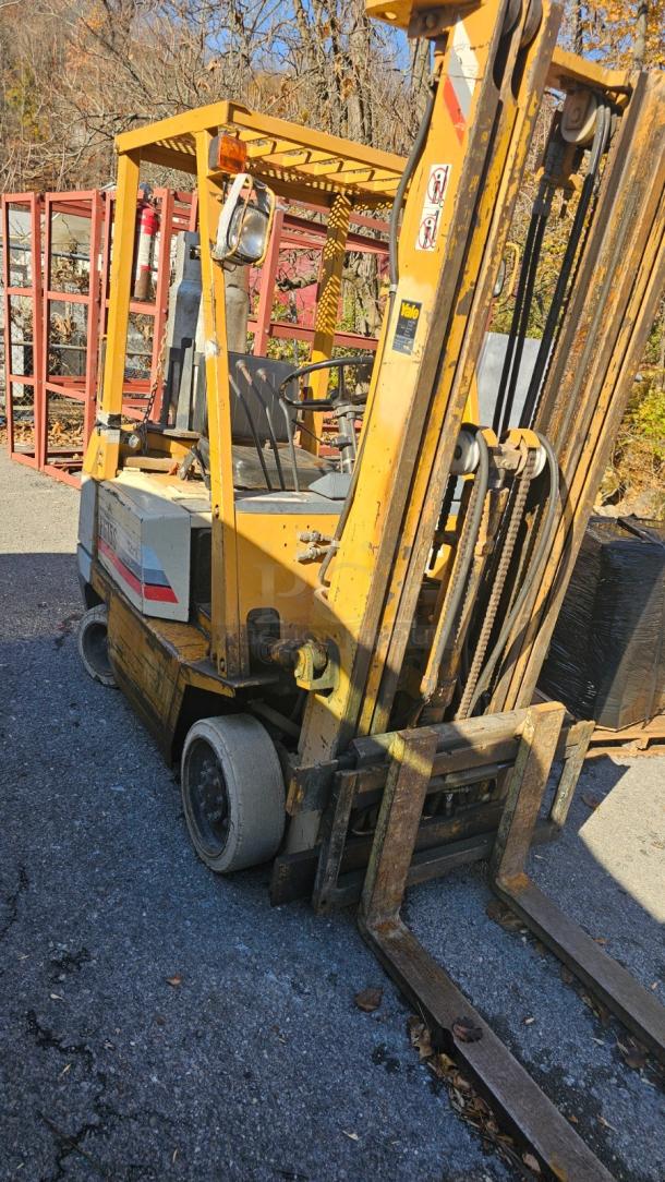 KOMATSU FG 15ST-2 forklift in good condition, yellow with visible wear. Features lifting mechanism and sturdy wheels.