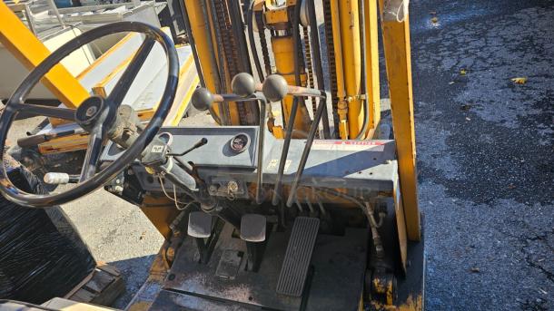 KOMATSU FG 15ST-2 forklift, good condition, steering wheel, control levers, and pedals visible. Model and warning labels intact.