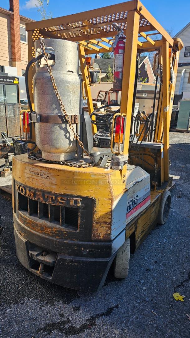 KOMATSU FG 15ST-2 Forklift in good working condition, showing visible wear. Equipped with a gas tank.