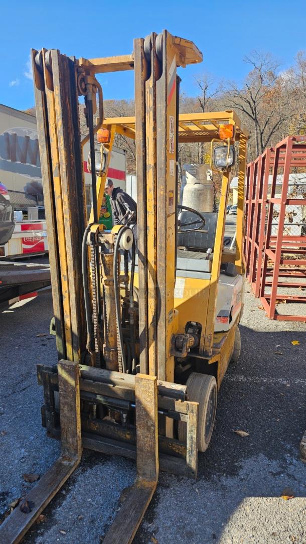 KOMATSU FG 15ST-2 Forklift, yellow, in good working condition, visible controls and lift mechanism, outdoor setting.
