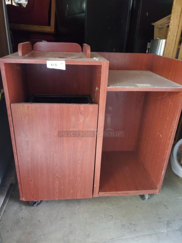 Wood tray top receptacle with casters, featuring a reddish-brown finish, signs of wear. Label marked "111."