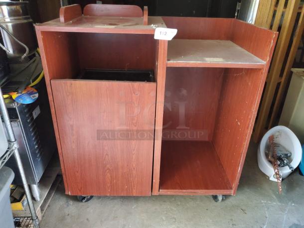 Wood tray top receptacle with wheels, dual compartments, in used condition. Features label marked "112." Ideal for restaurants.