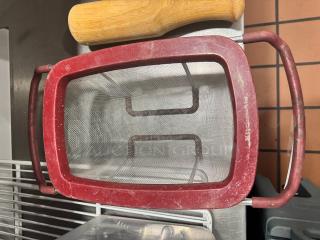 Red KitchenAid colander/strainer with mesh basket and handles, showing signs of wear.