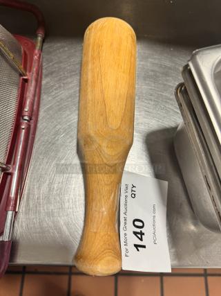 Wood muddler with smooth finish, used for cocktail making. Auction tag reads "140" and "PCI Auctions."