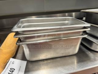 Lot of 3 stainless steel food pans, used, with slightly worn edges. Auction tag with lot number visible.