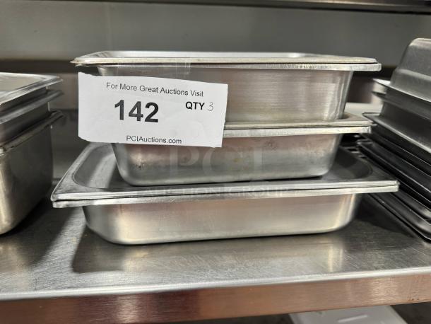 Lot of 3 stainless steel food pans with lid, good condition, stacked, tag indicating auction lot 142 for quantity 3.
