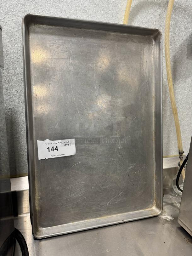 Full-size aluminum baking pan BIDX5, used condition, shows surface scratches. Auction label "144 QTY 5" attached.