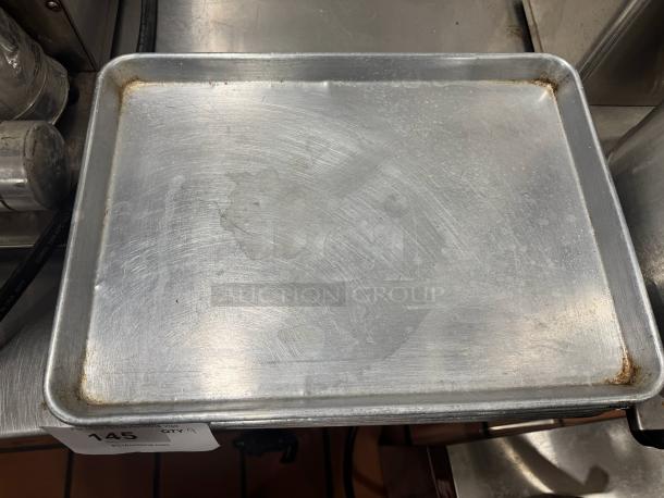 Half size baking pan BIDX9, aluminum, used condition, visible wear marks, auction tag 145 visible on the side.