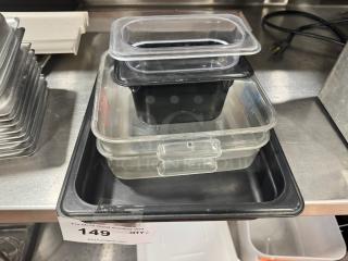 Lot of 6 plastic food pans, stacked, various sizes, clear and black. Used condition, auction tag with lot number 149 visible.