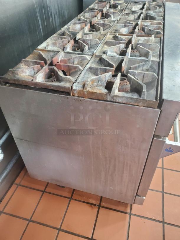 Imperial NG 10 Burner Stove with 2 ovens, stainless steel, visible wear, suitable for commercial kitchens.