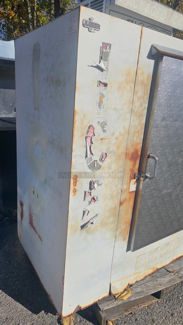 Commercial outdoor ice merchandiser by Leer, tested and working. Visible wear and rust, faded "ICE" lettering, sturdy handle.