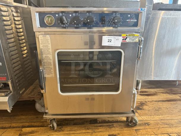 ALTOSHAAM 767-SK Cook & Holder Smoker Oven, stainless steel, visible control knobs, glass door, warning labels, on casters.