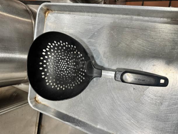 Farberware skimmer with black perforated scoop and ergonomic handle. Brand name visible on handle. Good condition.