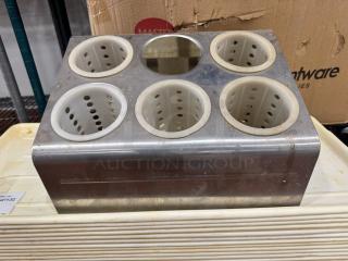 Stainless steel flatware organizer with five perforated plastic cylinders, missing one. Signs of wear visible.