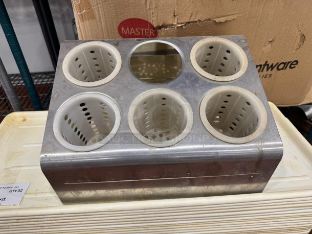 Six-hole stainless steel flatware organizer with five perforated plastic cylinders, one missing, in used condition.