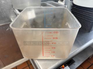 Clear 12qt food storage container with red and blue measurement markings on the side, used condition.