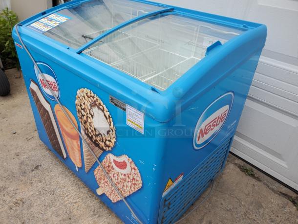 AHT RIO S 100 ice cream freezer merchandiser with Nestlé branding, vibrant graphics, clear glass lid, and solid condition.