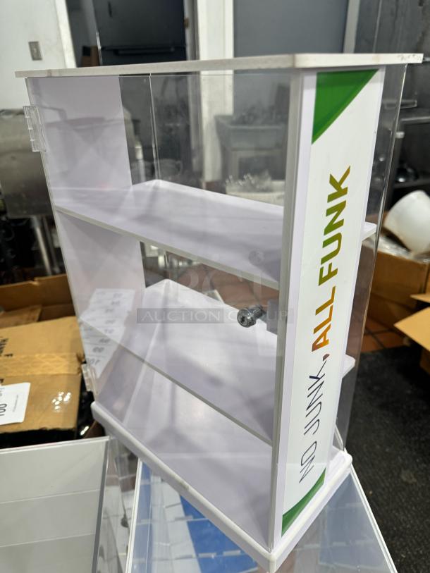 Acrylic display cabinet with two shelves, clear panels, and a lock. Features "No Junk, All Funk" label on the side.
