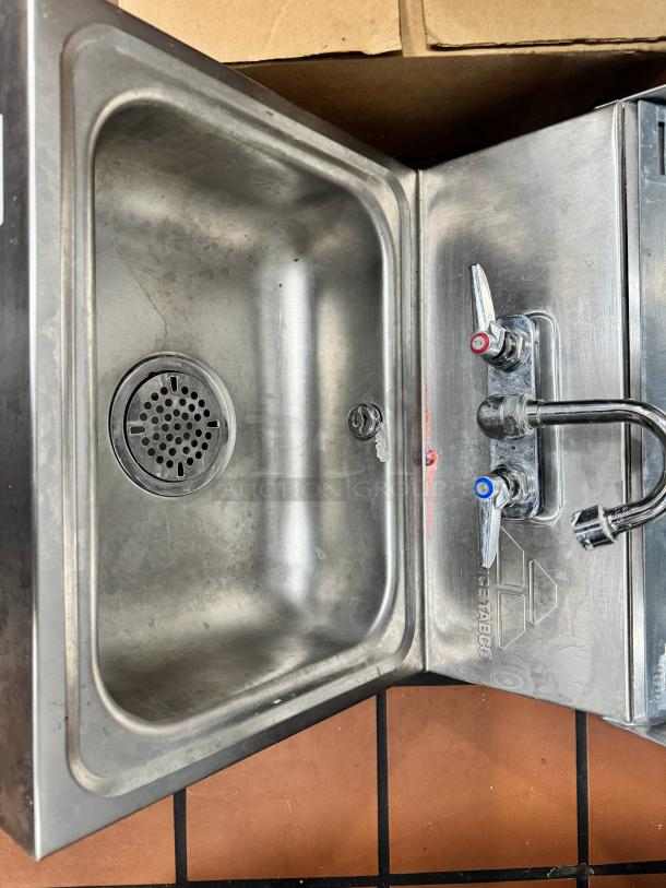 Advance Tabco stainless steel wall-mounted hand sink with dual faucets, soap, and fold paper towel dispenser, used condition.