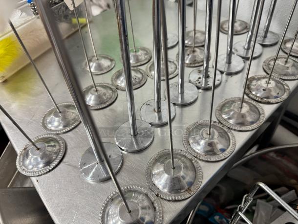 Lot of 26 silver table card holders with round bases, stainless steel rods, slight signs of wear, for auctions or events.