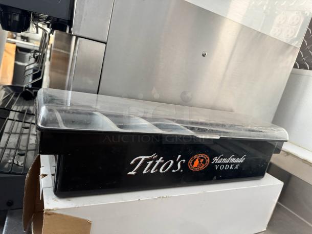 Tito's Vodka-branded condiment tray with clear lid, multiple compartments; used condition, ideal for bar setups.