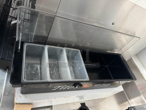 Clear condiment tray with multiple compartments, labeled "Tito's Handmade Vodka," showing minor wear.