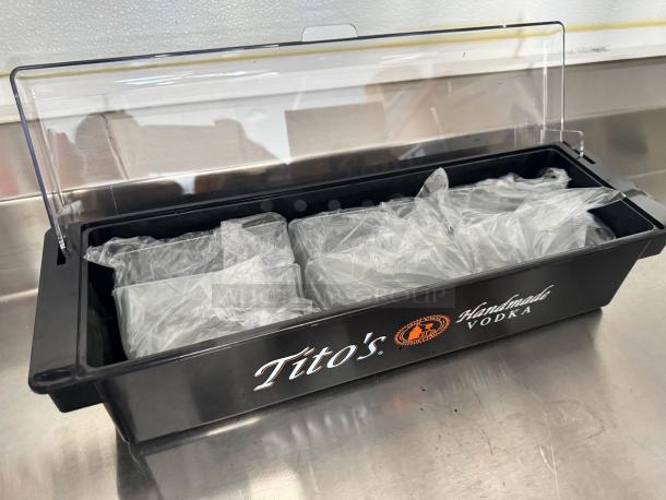 Brand new Tito's condiment tray with clear lid, featuring multiple compartments with protective wrapping, ideal for bar use.