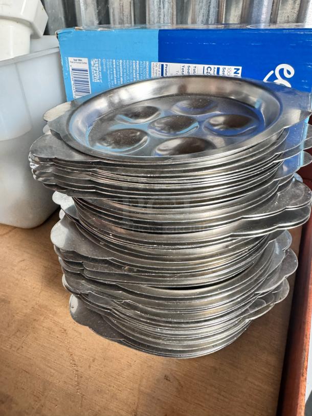 Stack of stainless steel escargot dishes, model BIDX25, in good condition. Each dish features six compartments.
