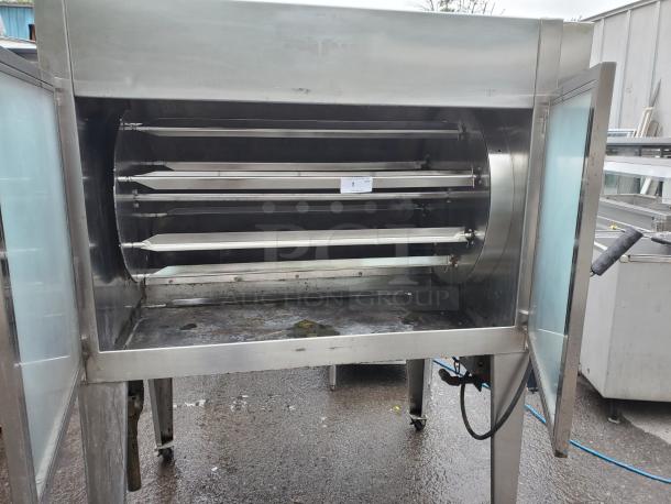 HARD INFERNO natural gas rotisserie oven, stainless steel exterior, three spits, open doors, industrial-grade condition.