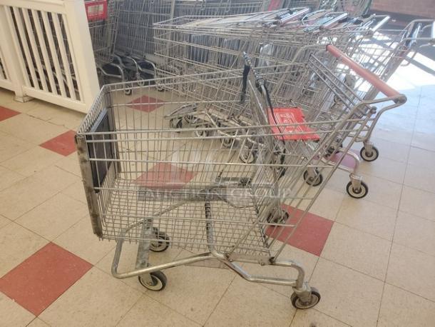 Lot of 2 metal shopping carts in used condition, featuring swivel casters and plastic handles.