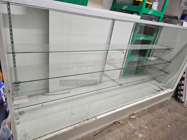 6ft glass display case BIDX2 with three shelves, sliding doors, and a metal frame. Visible wear and dirt marks.
