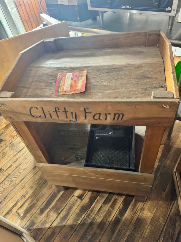 Vintage-style wooden display with rustic finish, labeled "Clifty Farm." Includes a shelf and removable tray. Good condition.
