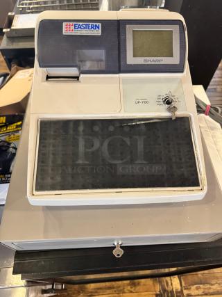 Sharp UP-700 POS terminal and cash register, featuring a keypad and display. Includes keys. Label from Eastern Business Machines.