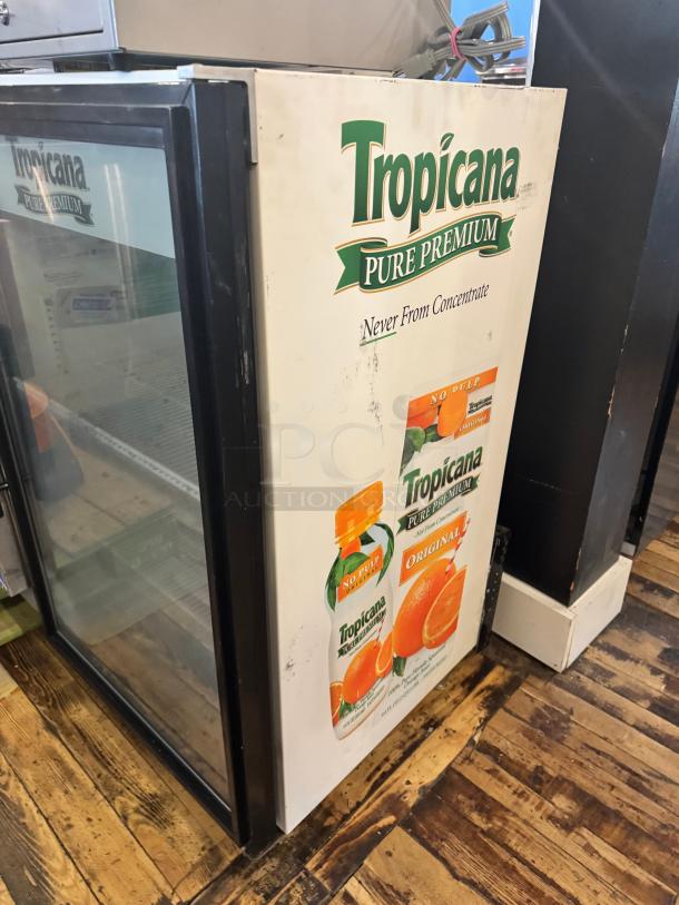 TRUE GDM-07 glass door cooler merchandiser, Tropicana branding, used condition, suitable for beverages, visible shelving.