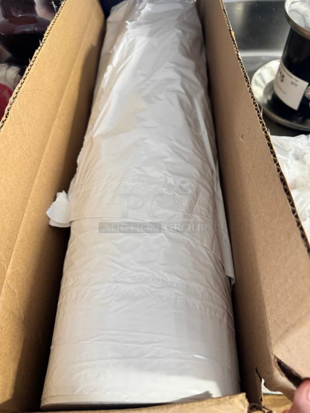 Roll of meat and dairy case liner in white, new condition, partially unrolled in a cardboard box.
