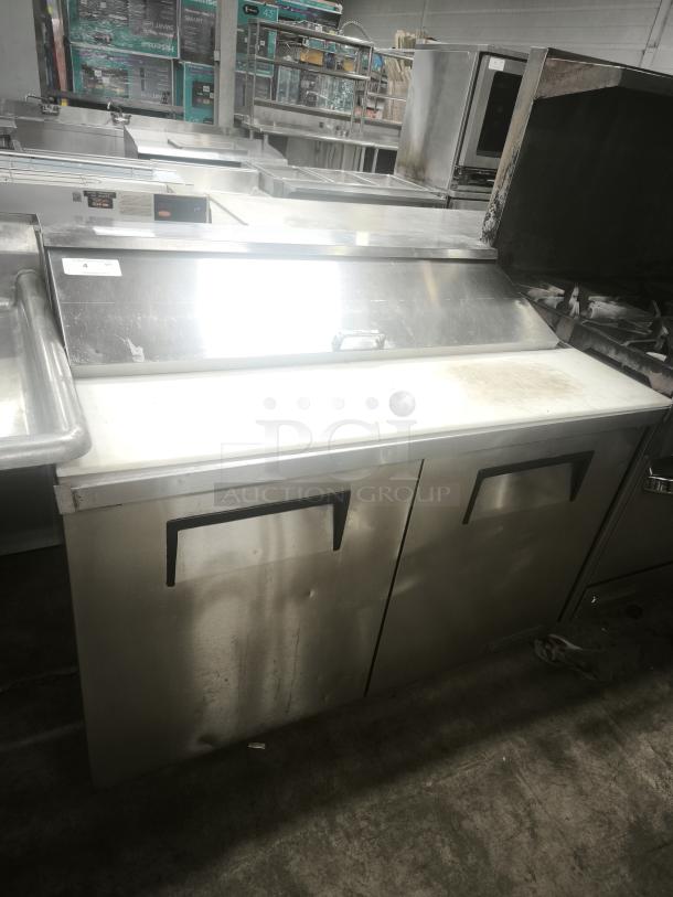True 48″ refrigerated prep table, model TSSU‑48‑12‑HC, stainless steel, commercial use, slight surface wear visible.