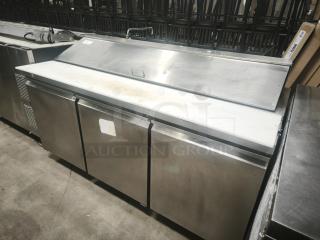 Heavy-duty 3-door refrigerated sandwich prep table with stainless steel finish, showing signs of use.