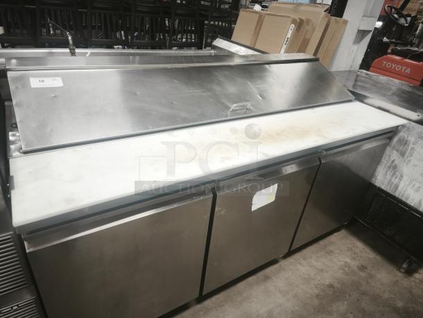 Heavy-duty 3-door refrigerated sandwich prep table with stainless steel exterior, top work surface, and visible wear.