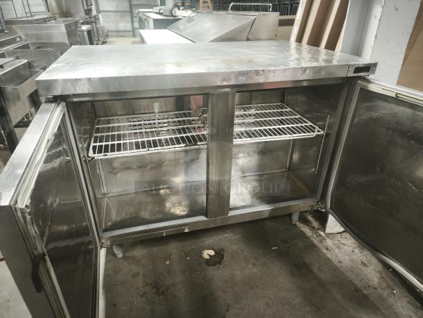 Kelvinator KCHUC48F 48" undercounter freezer with two sections and doors, visible metal shelves, good condition.