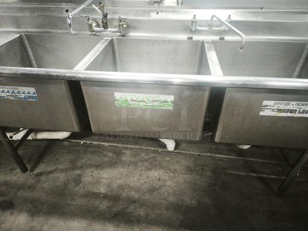 Heavy-duty 3-compartment stainless steel sink with labeled sections for washing, rinsing, and sanitizing. Good condition.