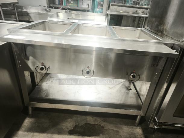 Heavy duty stainless steel steamer with triple compartments, visible control knobs, and sturdy construction.
