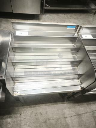 Heavy-duty metal pan rack with multiple shelves. Tag indicates BK Resources model. Light wear visible, ideal for kitchen use.
