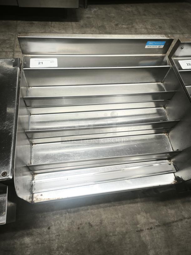 Stainless steel heavy-duty pan rack with multiple slots; label indicates model "BK" 28201265. Minor wear visible.
