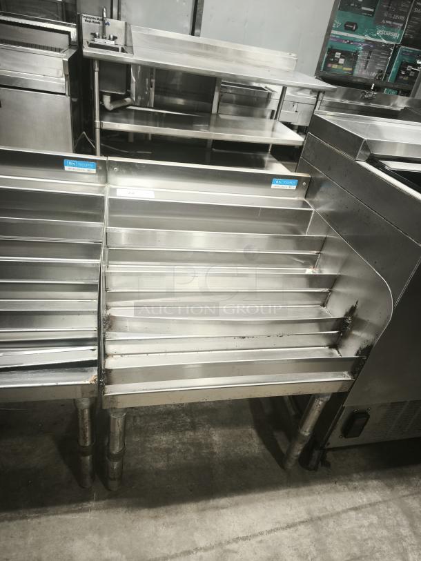 Heavy-duty stainless steel pan racks, multi-tiered, slightly used with visible wear, ideal for commercial kitchens.