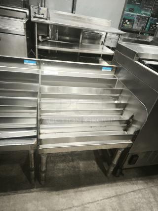 Heavy-duty stainless steel pan racks, multi-tiered, slightly used with visible wear, ideal for commercial kitchens.