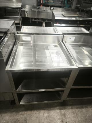 Heavy-duty stainless steel pan rack with two storage shelves and drainage feature, marked with quantity tags "23" and "24."