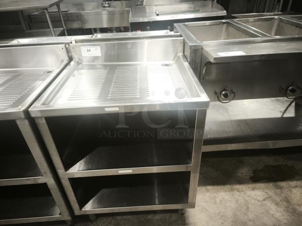 Heavy-duty stainless steel pan racks with two open shelves. Visible label indicates quantity: 24.