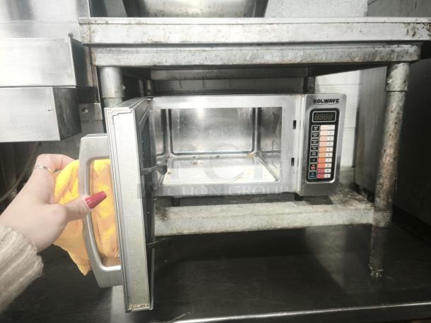 SOLWAVE commercial microwave with stainless steel finish, open door, visible digital controls, used in restaurant kitchen.