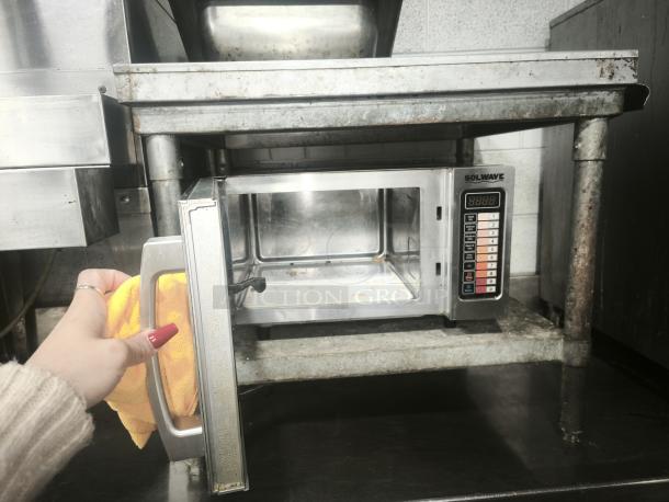 SOLWAVE commercial microwave in stainless steel, open door showing interior. Control panel with digital display. Used condition.